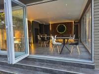 伯诺尼Lakefield Lodge - Halaal的带纱窗的门廊，上面有桌子和椅子