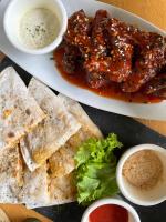 a plate of food with meat and pita bread and dips at Reef Hostel in Puerto Princesa City