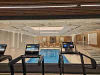a swimming pool with two laptops on tables in front of a window at Warsaw Presidential Hotel in Warsaw
