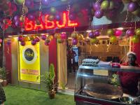 a man sitting at a counter in a restaurant with balloons at Lodge Babul in Kolkata