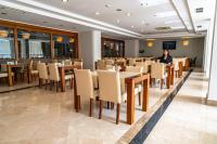 una mujer parada en un comedor con mesas y sillas en Mgs Salihoğlu hotel, en Burunabat