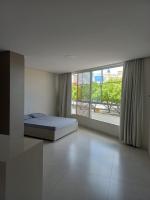 a bedroom with a bed and a large window at Pousada Studio Flat Jequié in Jequié