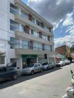 a large building with cars parked in front of it at Pousada Studio Flat Jequié in Jequié
