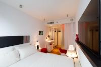 a bedroom with a white bed and a red chair at citizenM New York Times Square in New York