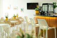 een restaurant met witte stoelen en tafels en een bar bij Hotel Dominican Barcelona in SJM