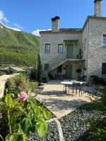 a large stone house with a table and a patio at Aristi boutique stonehouse with attic in Aristi