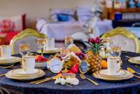 a table with a blue table cloth with pineapple and gold chargers at Riad Jnane Ines in Taroudant