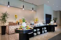 Grand Millennium Al Wahda Executive Apartments في أبوظبي: صف بوفيه مع أطباق وأوعية على طاولة