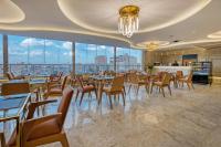 a dining room with tables and chairs and windows at Pyramids Plateau Hotel in Cairo