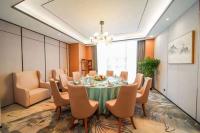 Un comedor con una mesa y sillas y una lámpara de araña. en Kelly Jinyue Hotel, en Chengdú