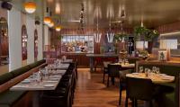 a restaurant with tables and chairs and a bar at Hôtel Reisen in The Unbound Collection by Hyatt in Stockholm
