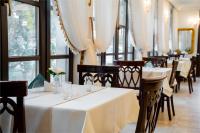 um restaurante com mesas, cadeiras e janelas brancas em Hotel Royal Plaza By TimHotels em Timişoara