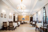 uma sala de jantar com mesas e cadeiras e um lustre em Hotel Royal Plaza By TimHotels em Timişoara
