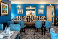 a dining room with a long table and blue chairs at Star Hotel Kingussie in Kingussie