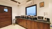 eine Küche mit einer Theke mit einer Mikrowelle und einem Fenster in der Unterkunft Hotel Tango Traxx in Amritsar
