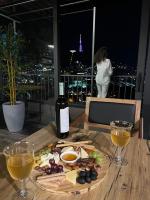 Una mesa con un plato de comida y una botella de vino. en Hotel Livin, en Tiflis