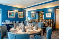 a restaurant with blue walls and tables and chairs at Star Hotel Kingussie in Kingussie
