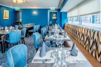 a restaurant with tables and chairs and blue walls at Star Hotel Kingussie in Kingussie