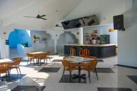 Un restaurante con mesas y sillas y un mostrador. en El Colibri Hotel, en Sosúa
