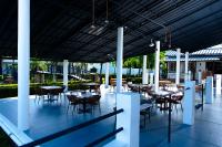 Un restaurante con mesas y sillas en un patio. en El Colibri Hotel, en Sosúa