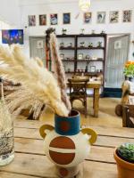 a vase with feathers in it on a table at FRONTERA 49 Roma Norte Hostal in Mexico City