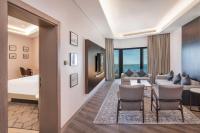 a hotel room with a bed and a living room at Sheraton Abu Dhabi Hotel & Resort in Abu Dhabi
