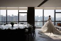 Una novia con un vestido de novia parada frente a una ventana en 武汉青莲景合酒店 Wuhan JING Hotel Wuhan Zoo International Expo Center, en Han-yang-hsien