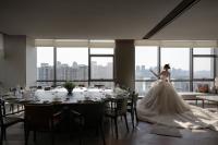 Una novia con un vestido de novia parada frente a una mesa en 武汉青莲景合酒店 Wuhan JING Hotel Wuhan Zoo International Expo Center, en Han-yang-hsien