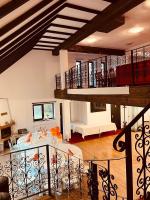 un ampio soggiorno con tavolo e scala di Pensiunea Alex a Marga