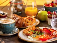a table with plates of food and a cup of coffee at Novotel London West in London