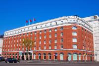 a large red brick building with two flags on top at Ramada by Wyndham Belfast in Belfast