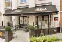a restaurant with tables and chairs in front of a building at Ramada by Wyndham Belfast in Belfast