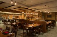 a restaurant with tables and chairs and a bar at DoubleTree by Hilton Resort & Spa Marjan Island in Ras al Khaimah