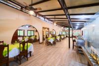 um restaurante com mesas e cadeiras em uma sala em Evergreen Lodge em Tortuguero