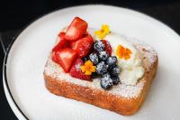 un trozo de pan con fruta en un plato blanco en Alma San Diego Downtown, a Tribute Portfolio Hotel, en San Diego