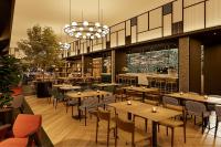Un restaurante con mesas y sillas y un bar. en Four Points by Sheraton Barcelona Airport, en Barcelona