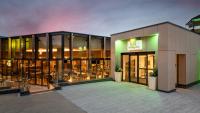 un edificio con muchas ventanas y mesas en Holiday Inn London Gatwick - Worth by IHG, en Crawley