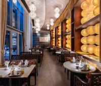 a restaurant with tables and chairs and a wall of windows at Kaya Palazzo Golf Resort in Belek