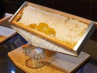 a cake sitting on a cutting board with a glass jar at Novotel London West in London