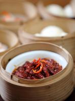 Un cuenco de madera con comida y salsa. en Lombok Plaza Hotel and Convention, en Mataram