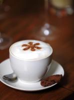 una taza de café en un plato con una galleta en Lombok Plaza Hotel and Convention, en Mataram