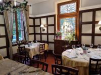uma sala de jantar com mesas e cadeiras e uma janela em Auberge de la Forêt em Le Nouvion-en-Thiérache