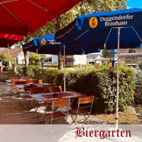 un grupo de mesas y sillas bajo una sombrilla en Landgasthof Hotel Zwickl, en Deggendorf