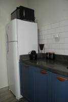 a kitchen with a white refrigerator and blue cabinets at Flat Sirena - São Vicente in São Vicente