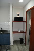 a room with a shelf with a sink and a mirror at Flat Sirena - São Vicente in São Vicente