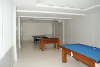 a room with a pool table and two tables at Flat Sirena - São Vicente in São Vicente