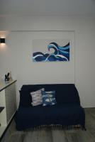 a living room with a blue couch with pillows at Flat Sirena - São Vicente in São Vicente