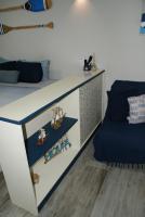 a bedroom with a bed and a blue chair at Flat Sirena - São Vicente in São Vicente