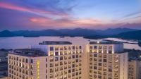 杭州市にあるMidtown Shangri-La, Hangzhou - around 5 minutes walking distance to West Lakeの湖と山の景色を望む大きな建物