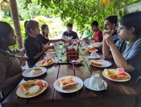 een groep mensen die rond een tafel zitten te ontbijten bij Villa 26 Weligama in Weligama
